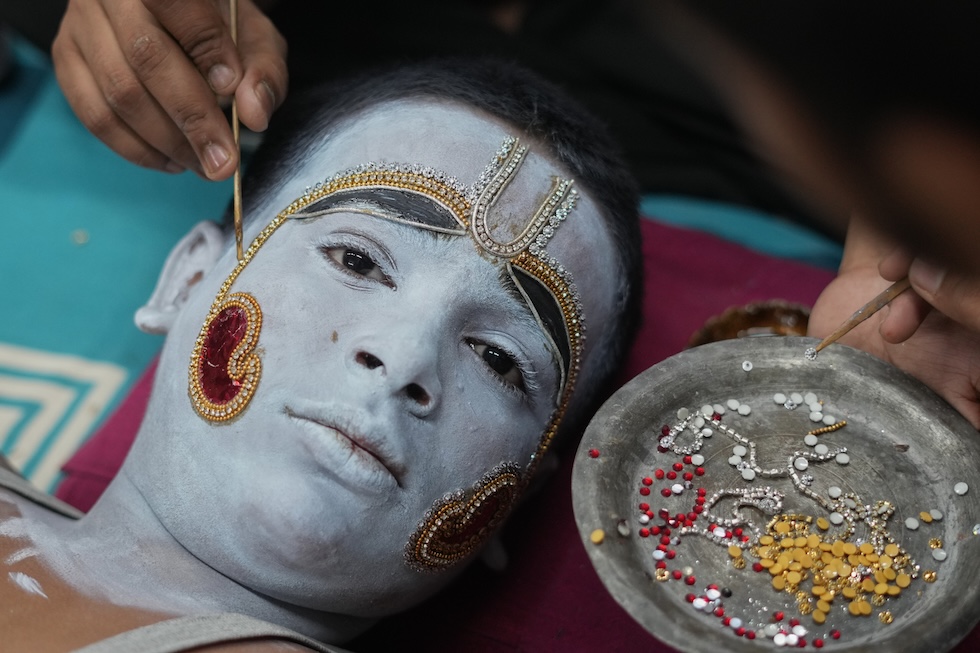 Un uomo viene truccato come Rama, un'eroe della mitologia induista considerato un'emanazione del dio Vishnu, prima di una celebrazione religiosa nel nord dell'India che celebra la sua vittoria contro il demone Ravana (AP Photo/Rajesh Kumar Singh)