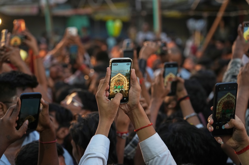 Persone fanno foto al Dussehra, un'importante festa induista (AP Photo/Rajesh Kumar Singh)