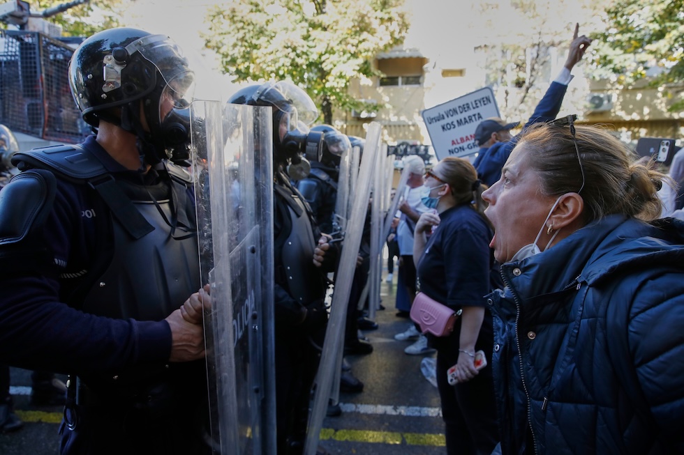 Una donna urla contro la polizia in tenuta antisommossa durante una protesta antigovernativa (AP Photo/Boris Grdanoski)
