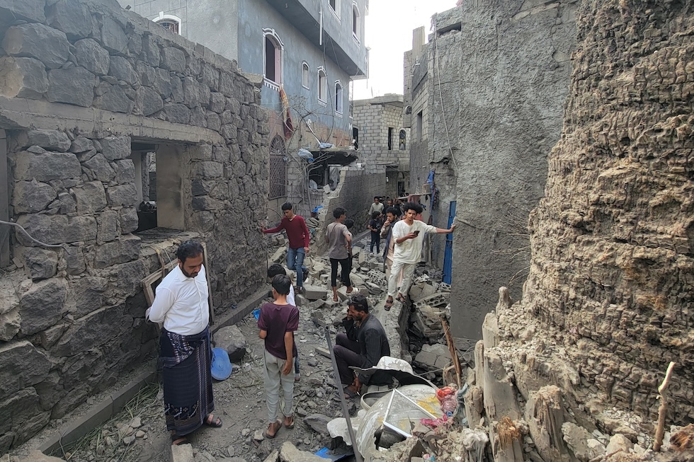 Alcune persone tra le macerie delle loro case, colpite da un attacco missilistico degli Houthi  (AP Photo/Marzouq Al Jabri)
