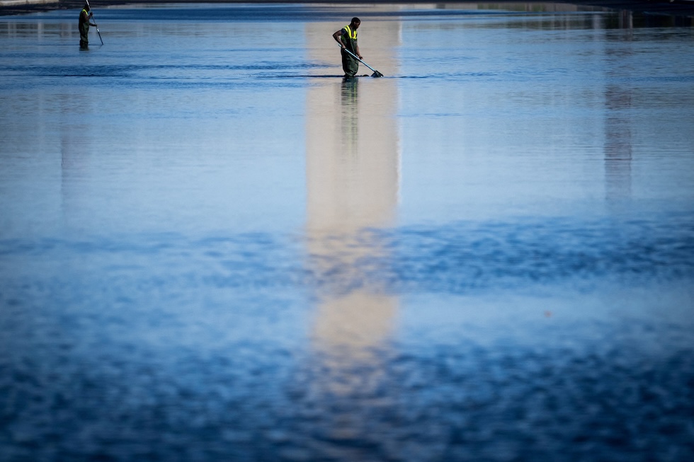 Alcuni lavoratori nella Reflecting Pool, la grande vasca rettangolare davanti al Lincoln Memorial (REUTERS/Nathan Howard)