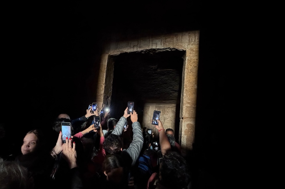 Turisti accalcati per riprendere il raggio di sole che illumina alcune statue nel santuario interno del Grande Tempio di Ramses II. Il tempio, costruito nel XIII secolo a.C., è orientato in modo che i raggi del sole attraversino l’ingresso e le sale interne fino a illuminare alcune statue in due giorni precisi dell’anno, generalmente il 22 febbraio e il 22 ottobre (AP Photo/Mohammed Salah)