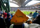 Uno spettatore con un cappello a forma di fetta di formaggio sugli spalti dello stadio assiste a un allenamento