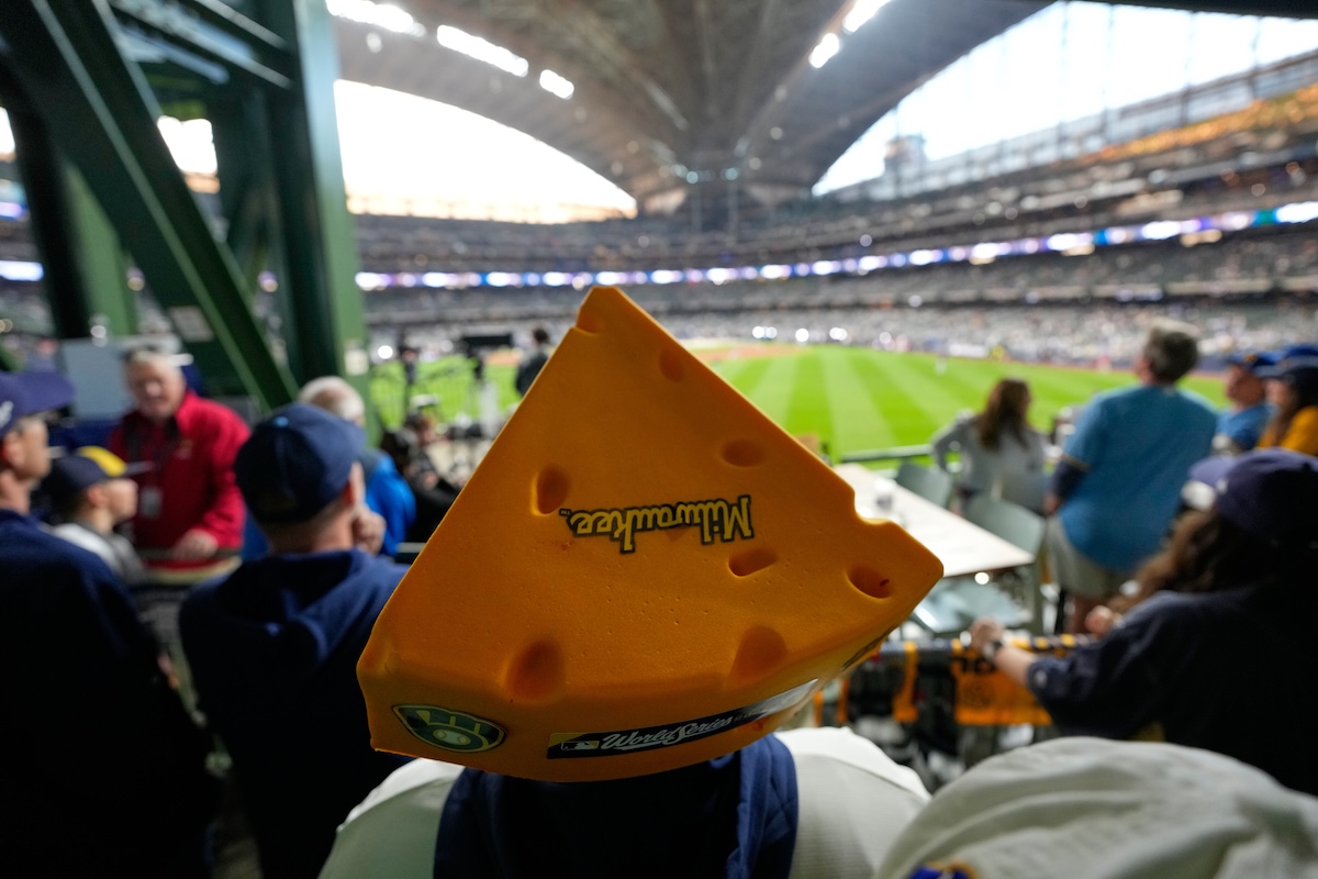 Uno spettatore con il “cheesehead”, il cappello a forma di fetta di formaggio usato dai tifosi dei Milwaukee Brewers, assiste all’allenamento prima della partita di baseball contro i Tampa Bay Rays, venerdì, la prima delle World Series della Major League, le finali del campionato nordamericano di baseball.  (David J. Phillip/AP)
