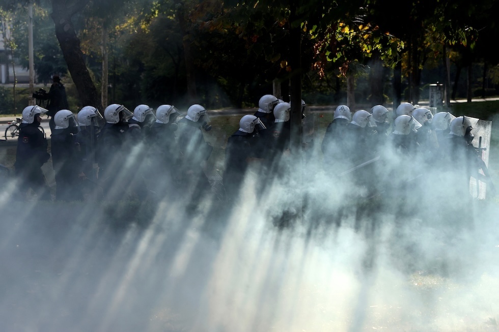 Agenti in tenuta antisommossa avanzano durante una manifestazione antigovernativa. (AP Photo/Hameraldi Agolli)
