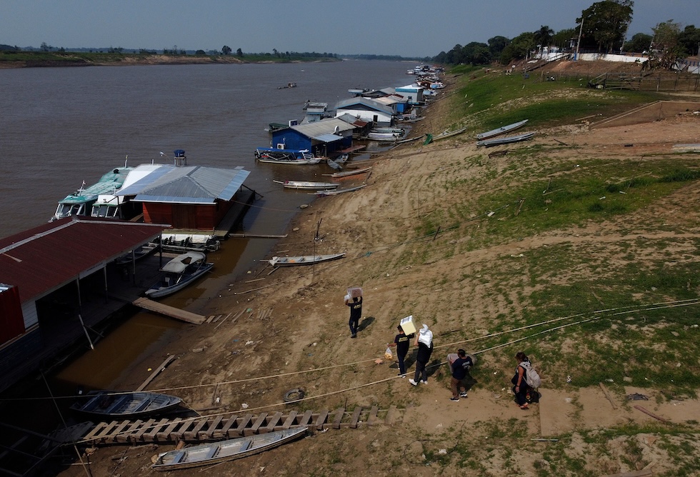 Alcune persone caricano le macchine per il voto elettronico su un’imbarcazione per trasportarle nelle comunità che vivono lungo il fiume, in vista del ballottaggio delle elezioni presidenziali brasiliane. (AP Photo/Edmar Barros)