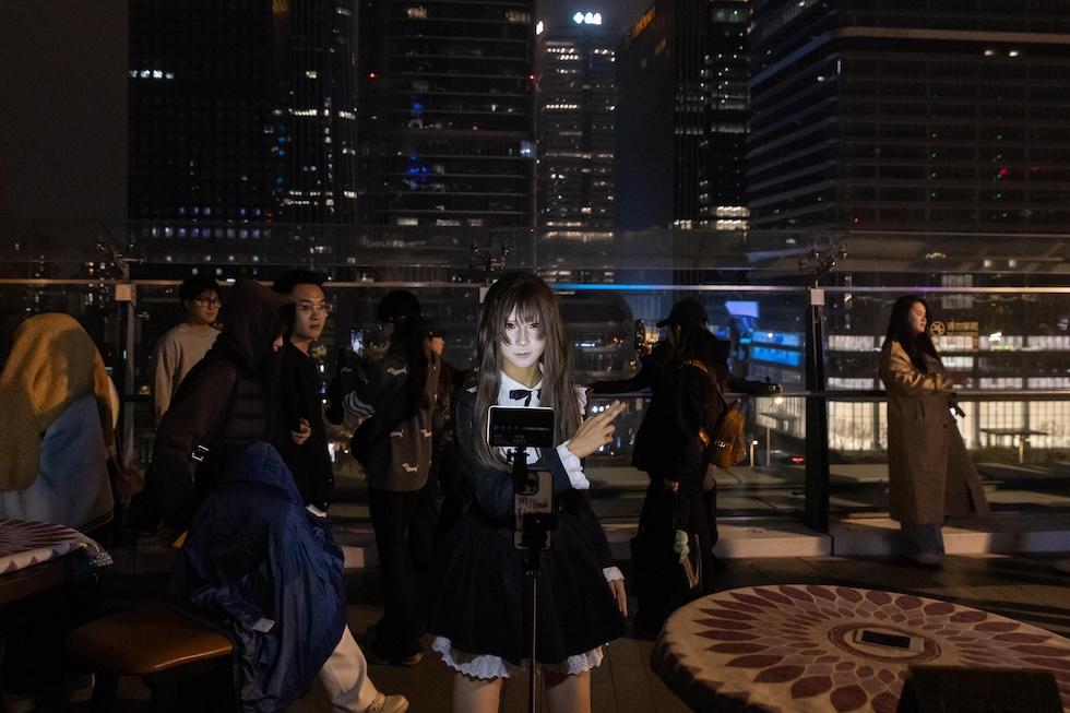 Una persona incosplay mentre balla davanti al cellulare. (ANSA/EPA/JESSICA LEE)