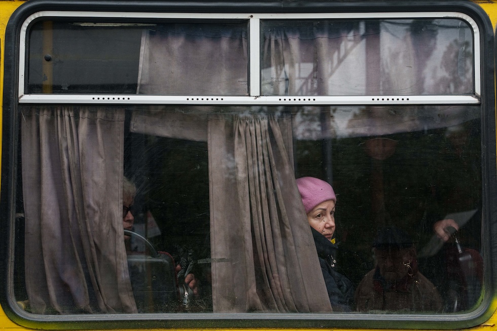 Una donna guarda fuori dal finestrino di un autobus durante la tregua umanitaria (AP Photo/Evgeniy Maloletka)