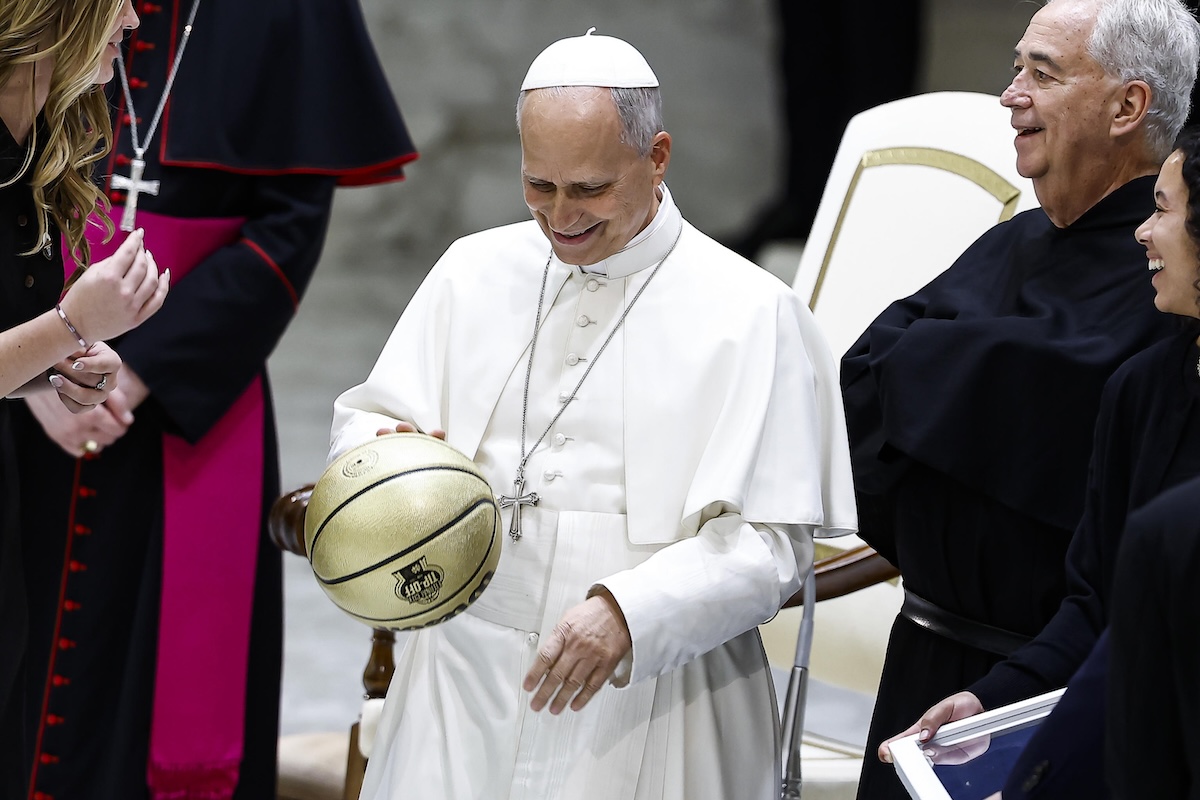 Papa Leone XIV con una palla da basket dorata regalatagli dalle squadre maschili e femminili delle università statunitensi di Villanova e Notre Dame, in visita in Vaticano (ANSA/ANGELO CARCON)